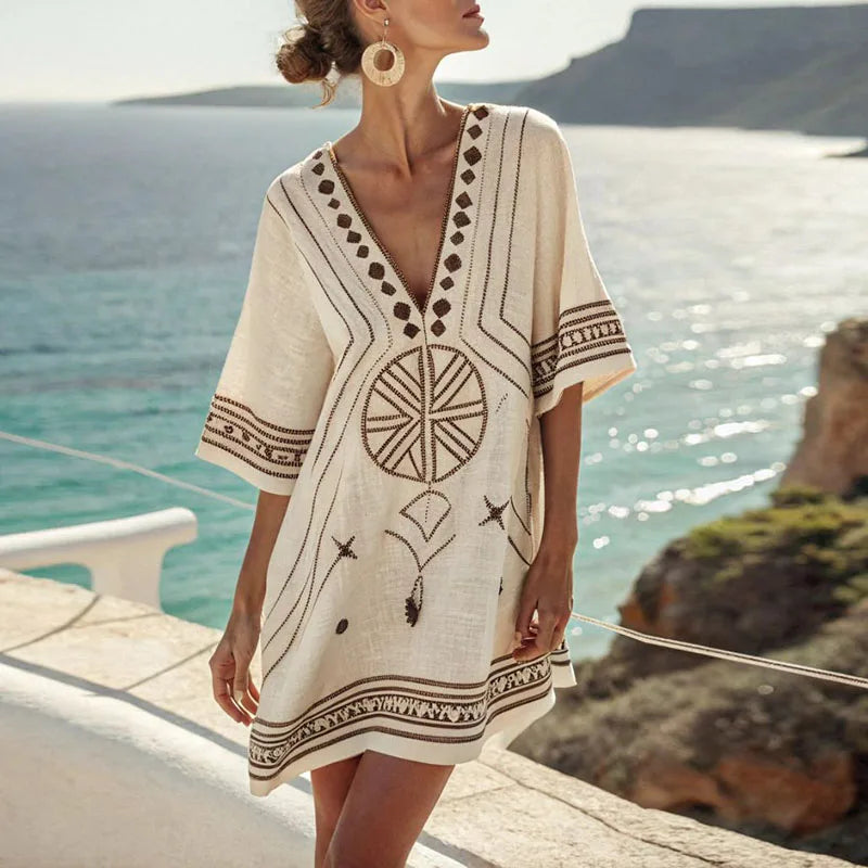 Vestido de playa fluido color blanco con escote v sobre arena dorada